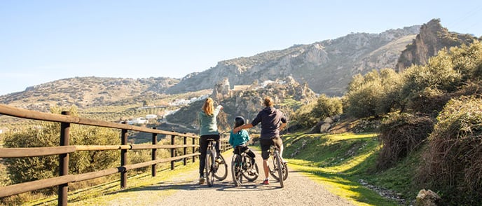 Tourist family travelling together on bikes in Swiss countryside