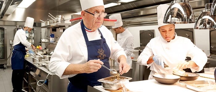 A discussion in the kitchen between a staff members and the chef