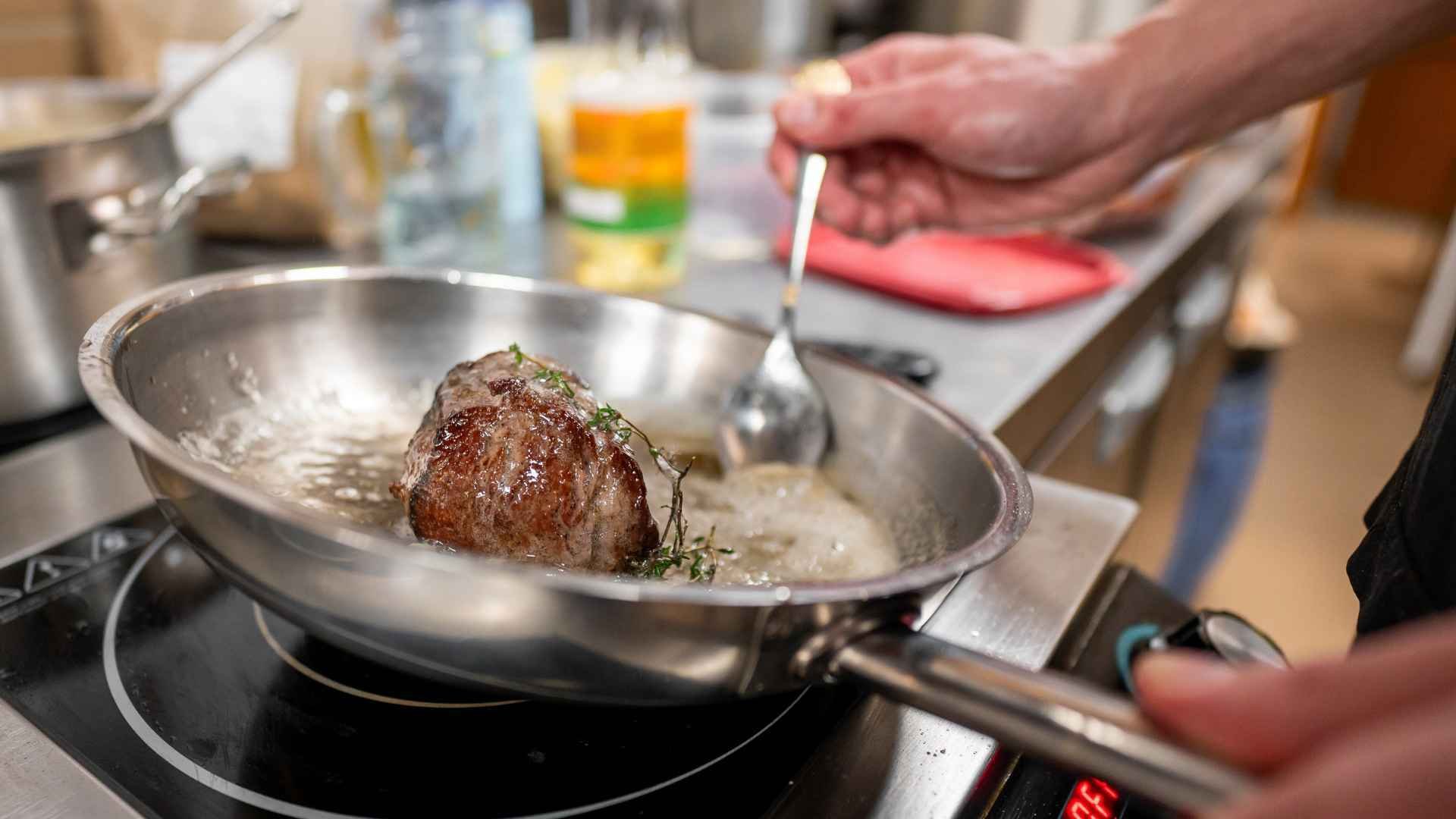 Chef searing a piece of meat