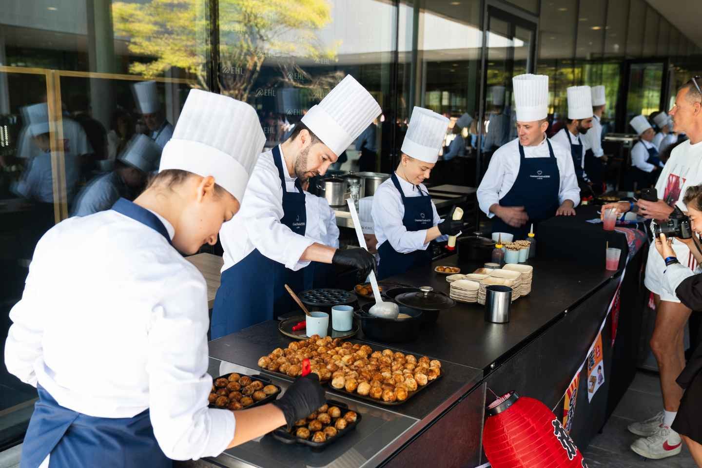 Many cooks are preparing finger food during a gourmet festival
