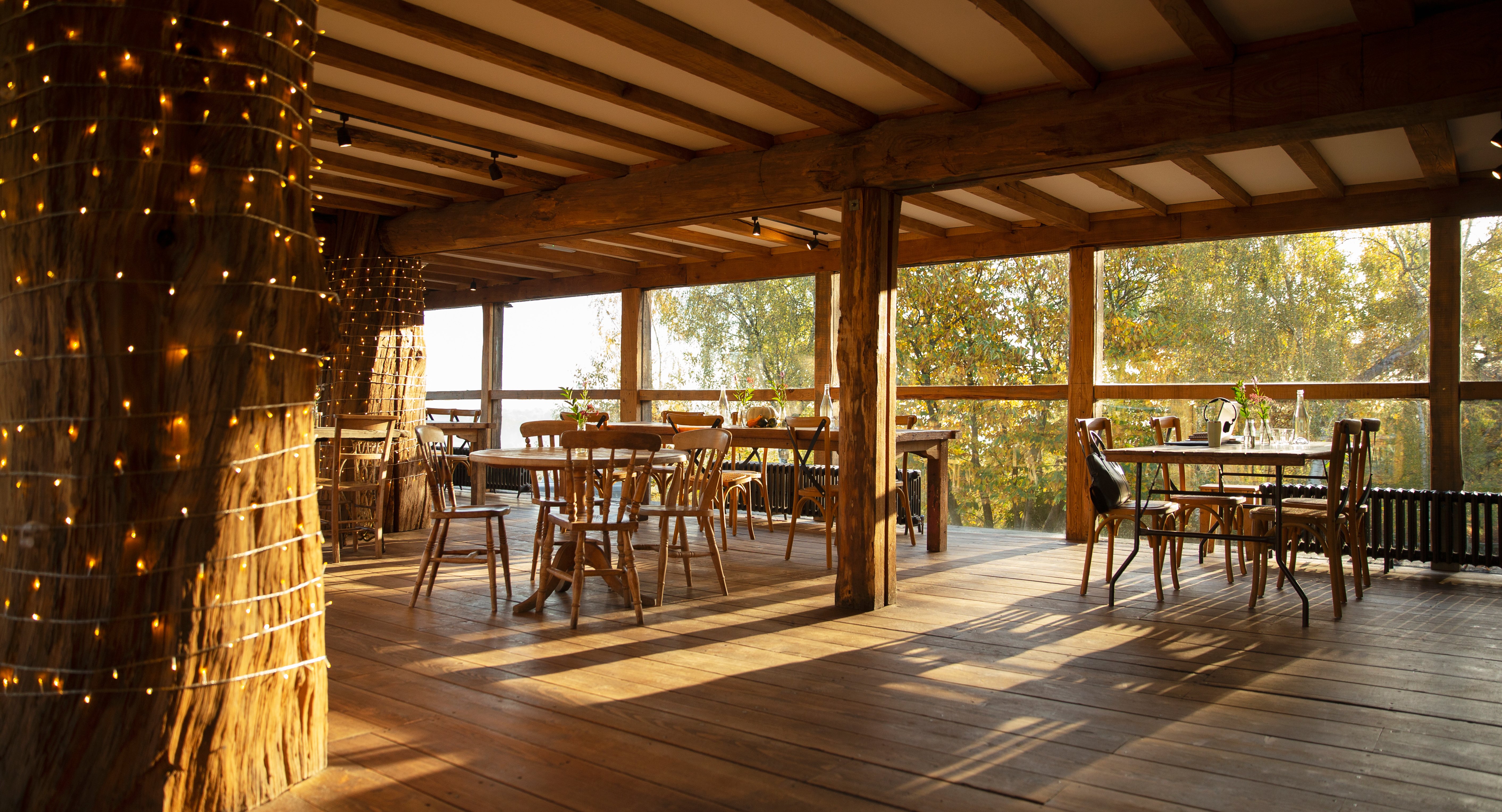 Wooden tables and chairs in sunny empty restaurant