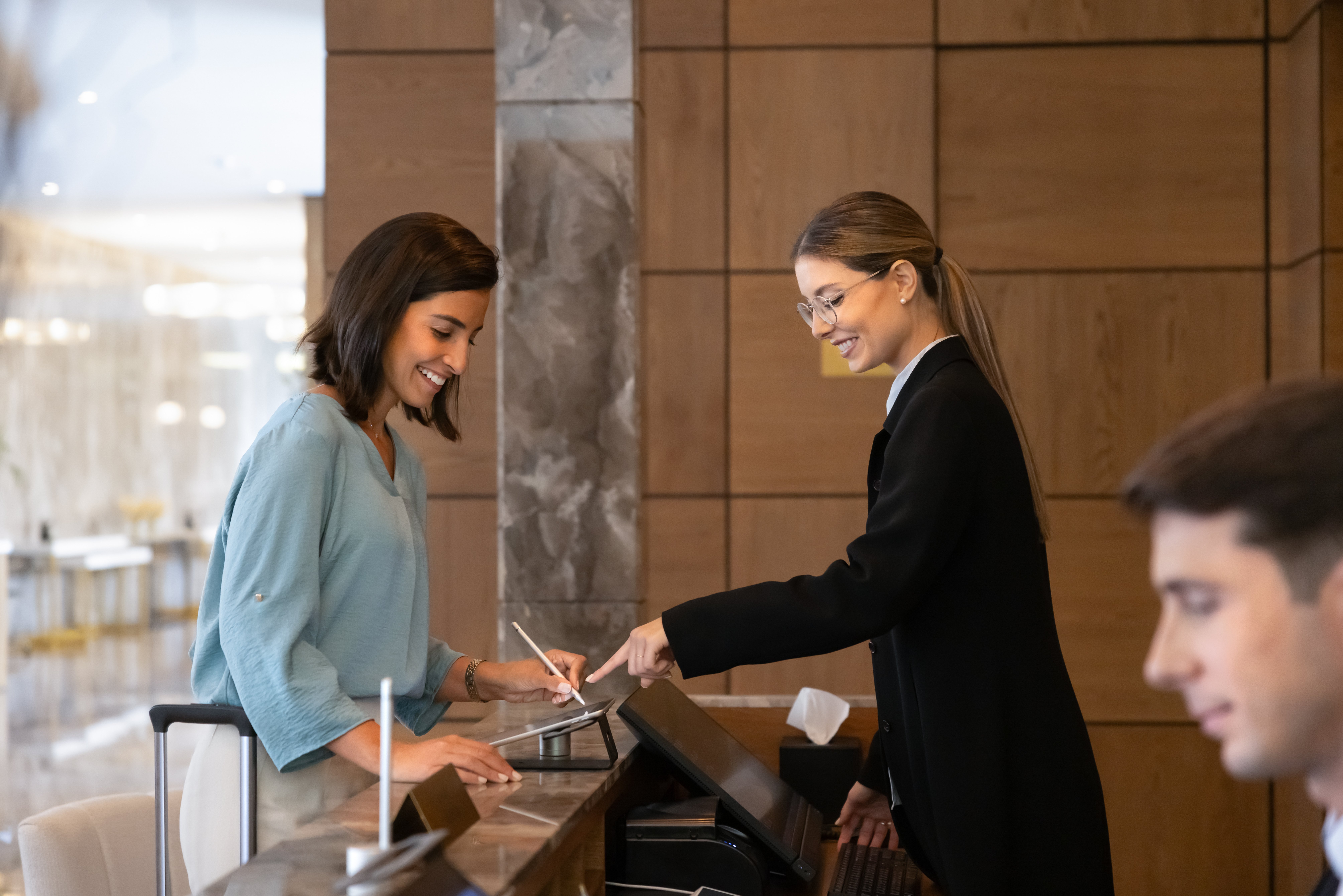 Woman traveler processing check-in on digital tablet signing electronic form