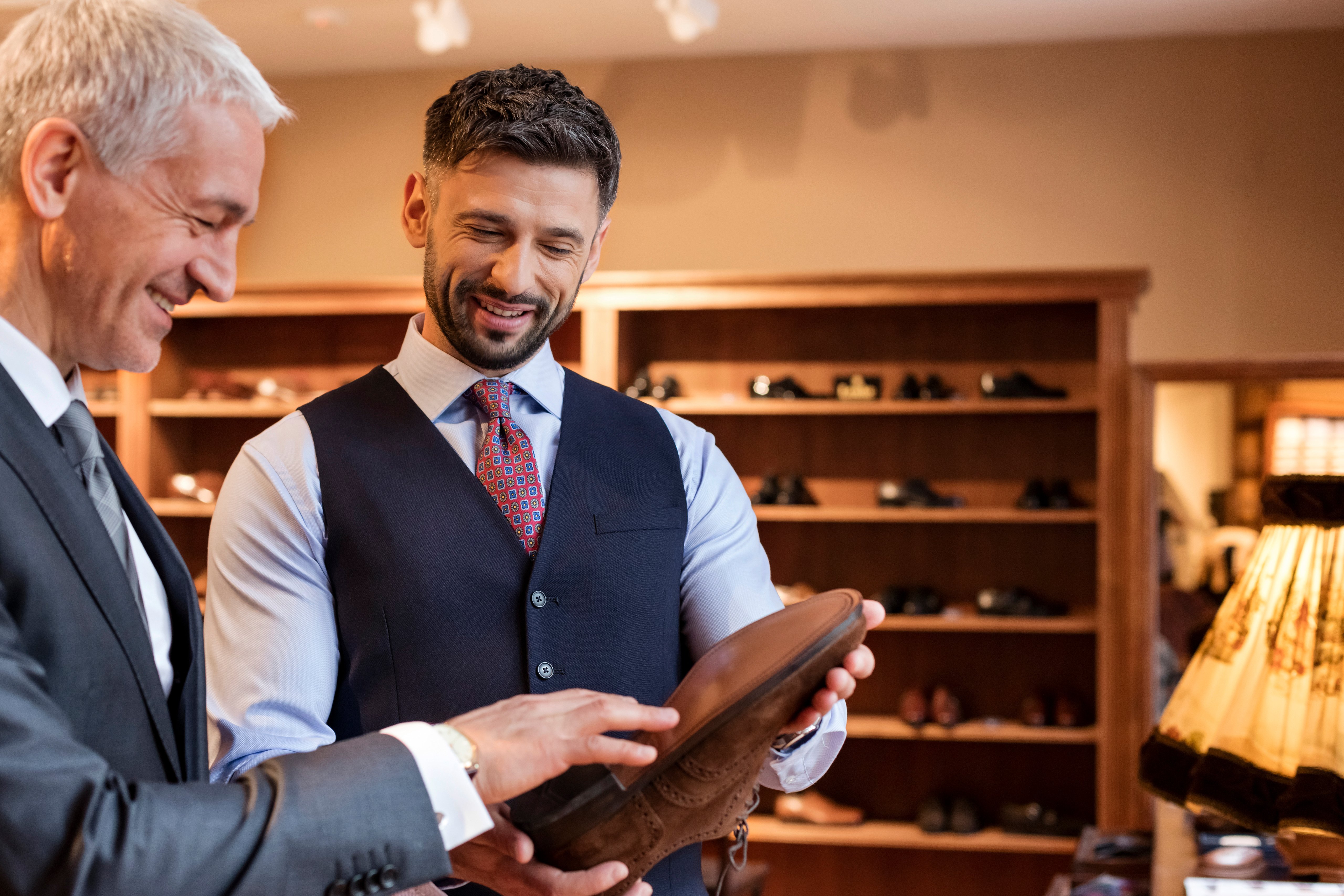 Worker showing dress shoes to businessman