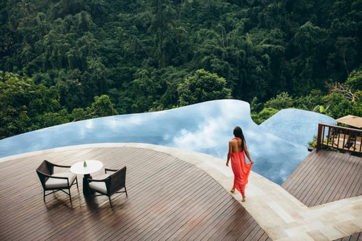 Woman walking near a swimming pool at luxury resort