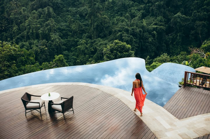 Woman walking near a swimming pool at luxury resort