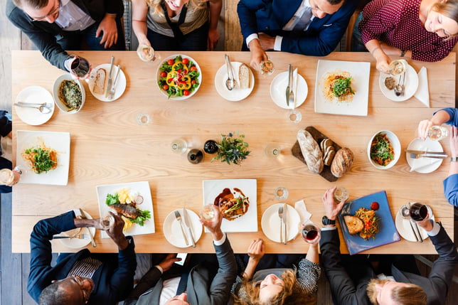 Diverse group enjoying meal together.