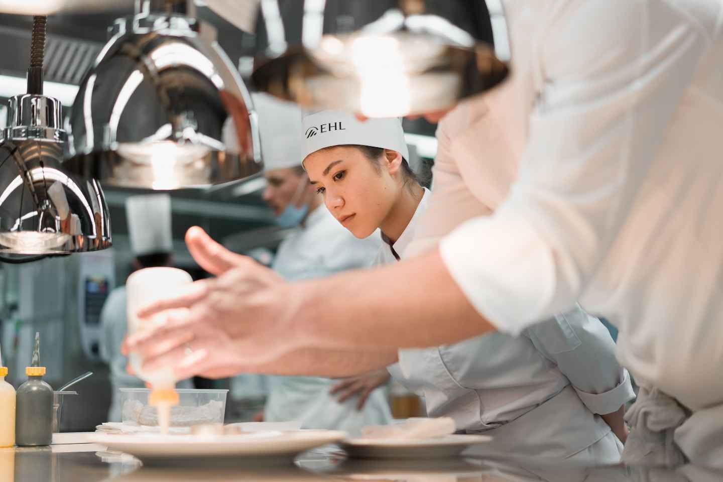 Student observing in kitchen at EHL gastronomic restaurant Berceau des Sens