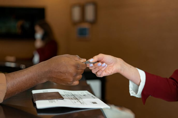 Handing over a credit card at a hotel reception