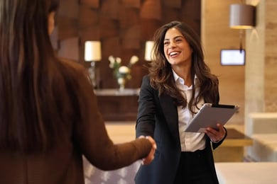 women handshaking in a hotel lobby