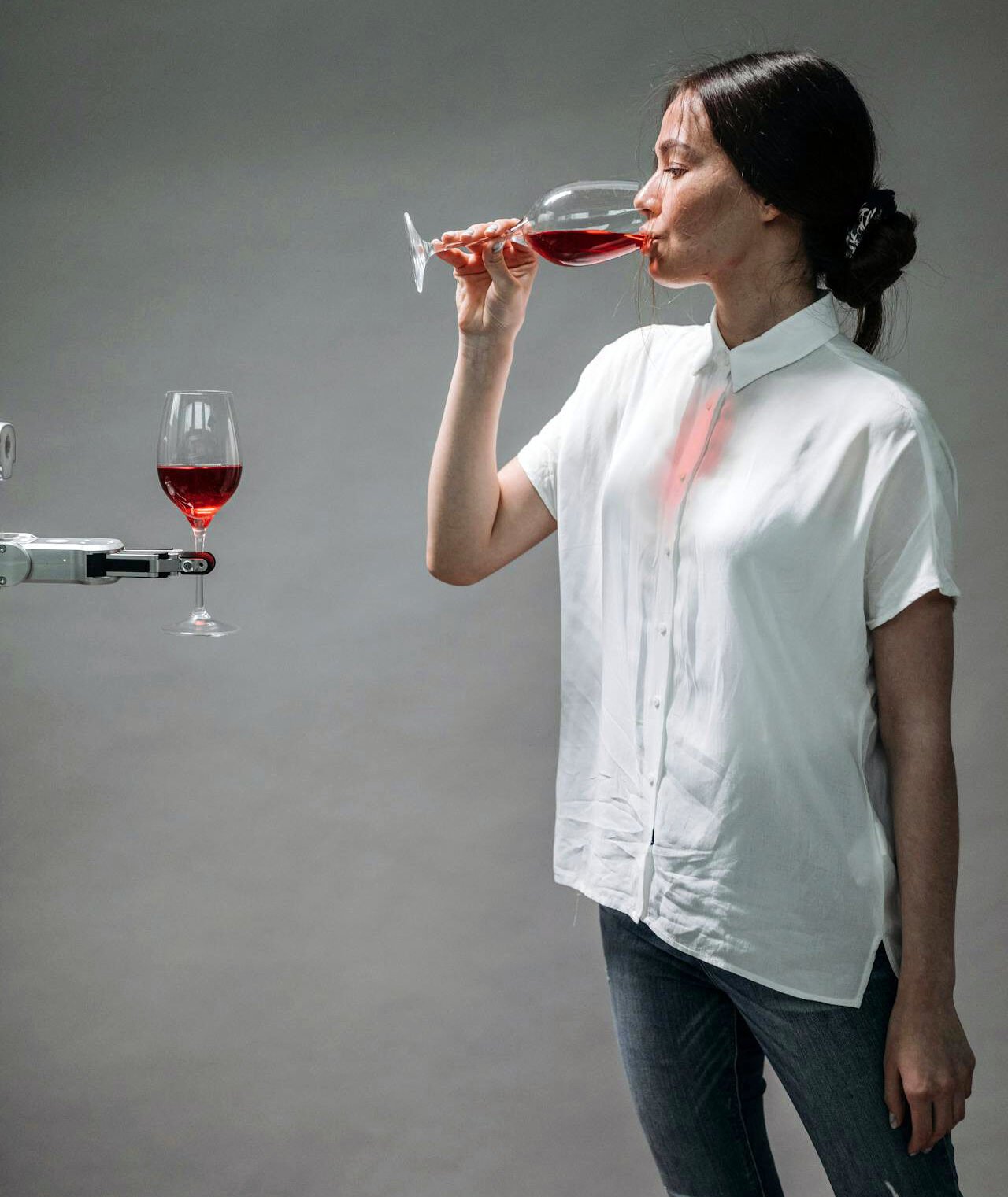 Person sipping wine with AI robot