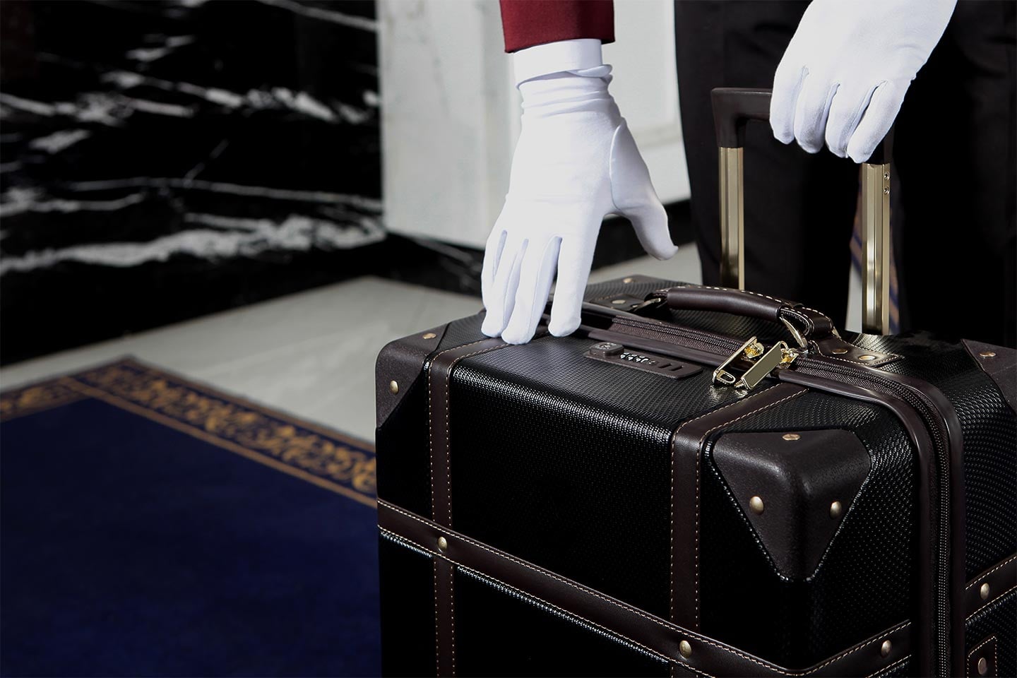White glove of a bell hop picking up luggage